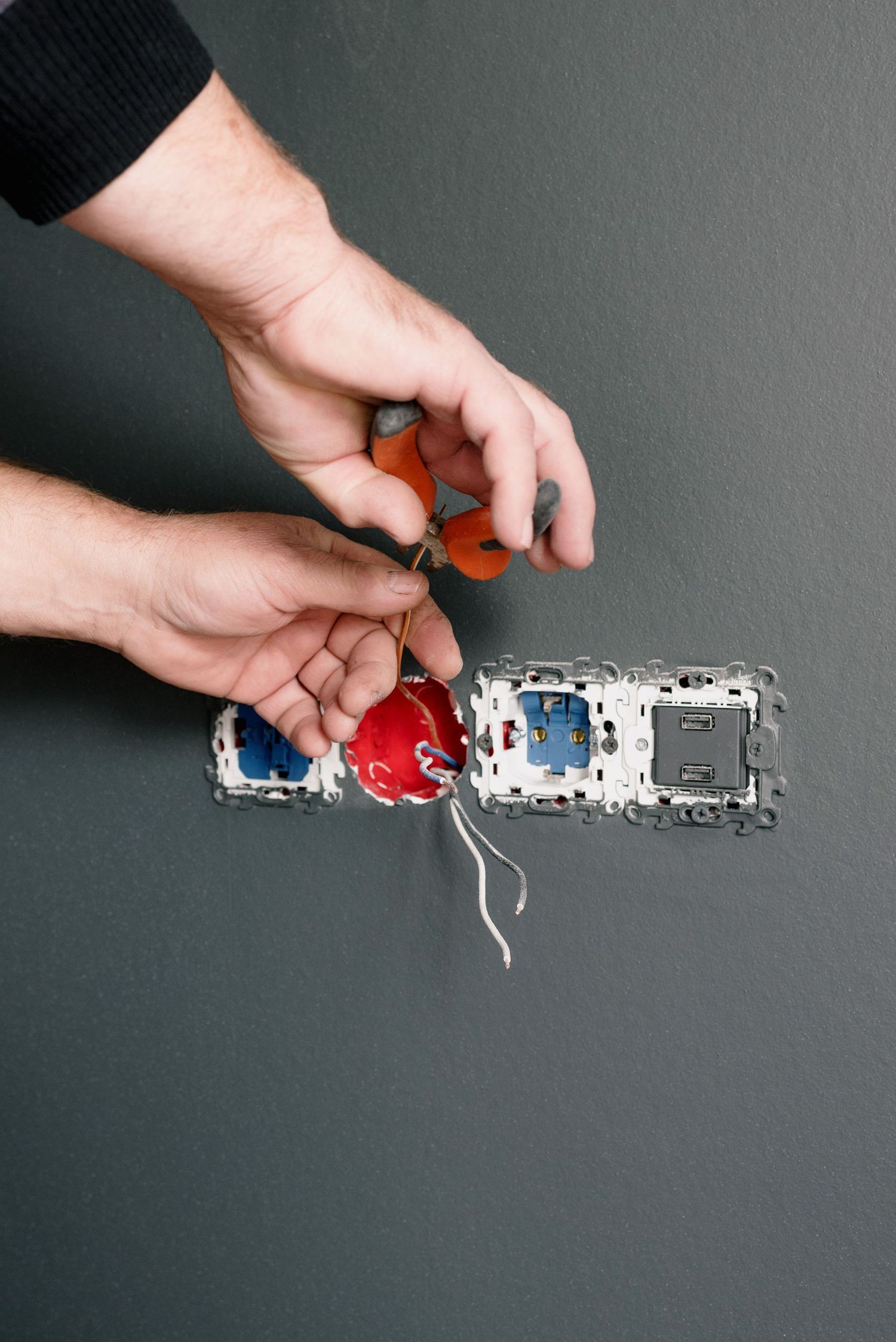 An electrician terminating wiring into a wall socket